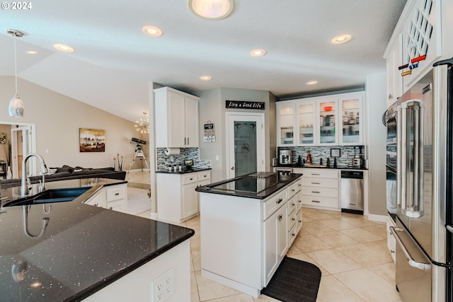 kitchen with sink, high end refrigerator, white cabinets, hanging light fixtures, and a center island