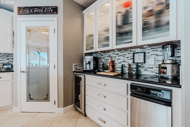 bar featuring light tile patterned flooring, tasteful backsplash, wine cooler, white cabinets, and stainless steel dishwasher