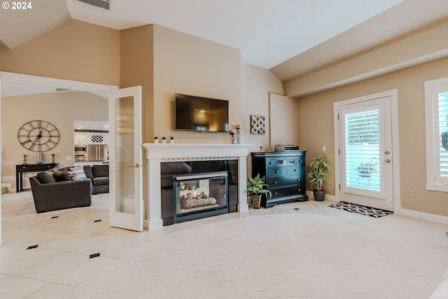 living room featuring vaulted ceiling, light tile patterned floors, and a fireplace