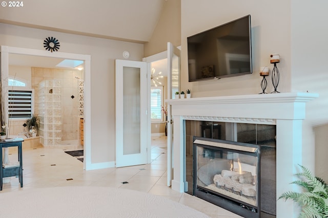 living room with a multi sided fireplace, lofted ceiling, and light tile patterned floors