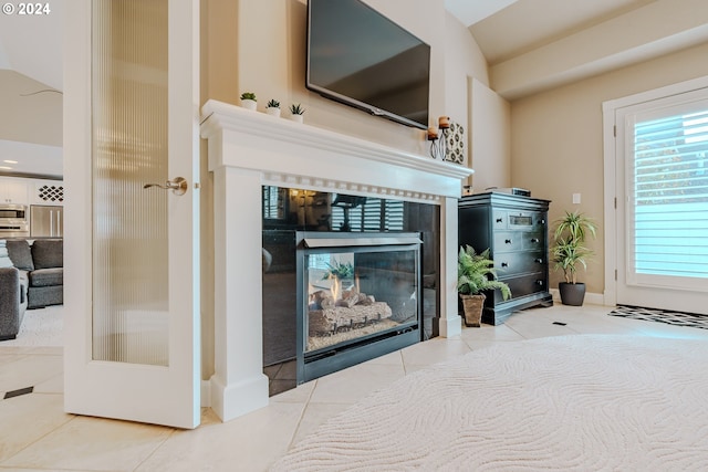 interior details featuring a tile fireplace and refrigerator