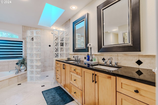 bathroom with vanity, separate shower and tub, tile walls, and a skylight