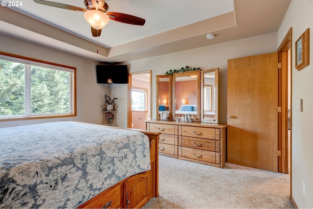 bedroom with multiple windows, ceiling fan, and light colored carpet