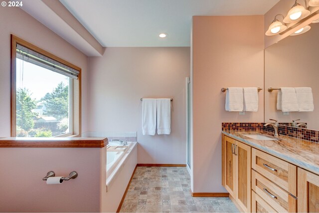 bathroom with a tub to relax in and vanity