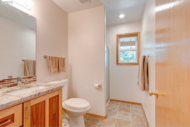 bathroom with vanity, tile patterned flooring, toilet, and an enclosed shower