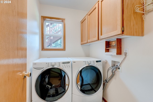 washroom with cabinets and washing machine and clothes dryer