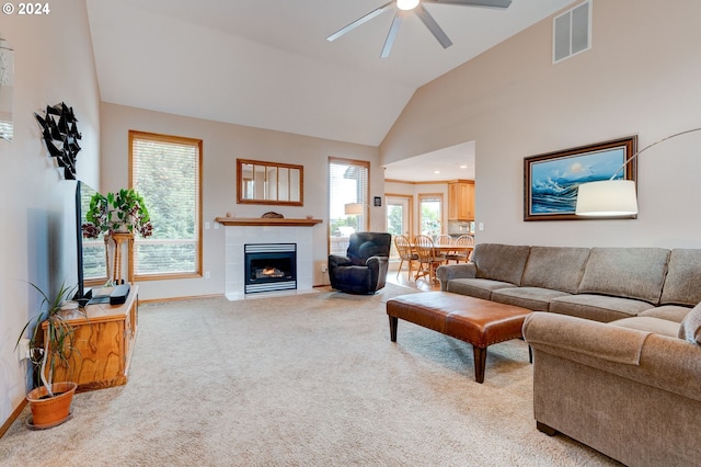 carpeted living room featuring ceiling fan, a fireplace, and high vaulted ceiling