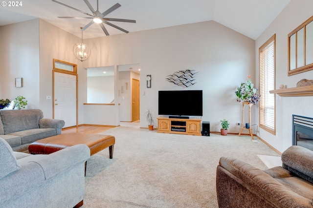 living room featuring ceiling fan with notable chandelier, carpet flooring, and high vaulted ceiling