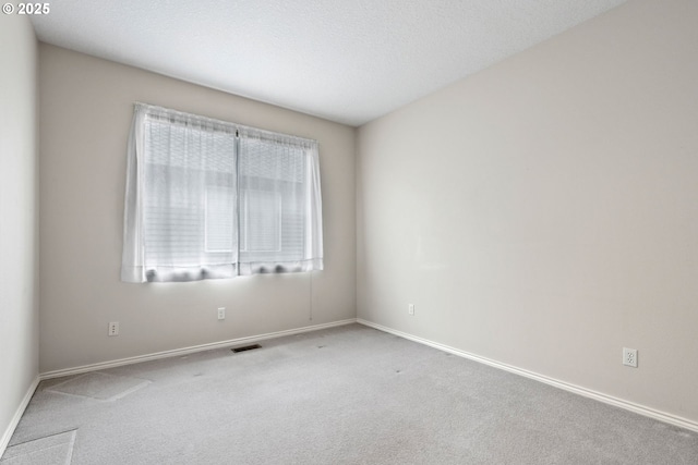 carpeted empty room with a textured ceiling