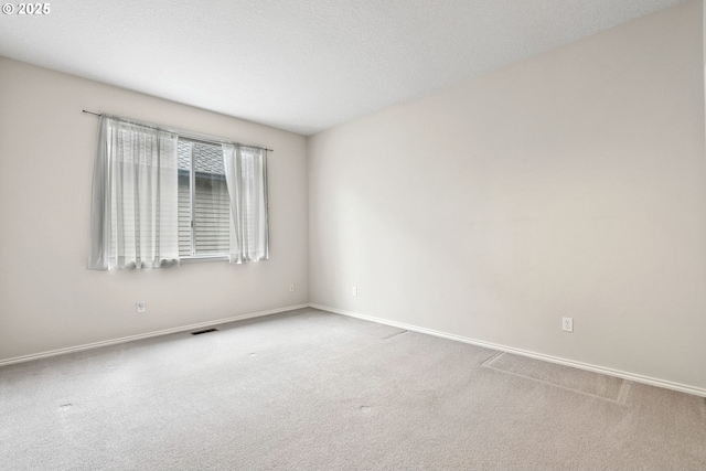 unfurnished room with carpet floors and a textured ceiling