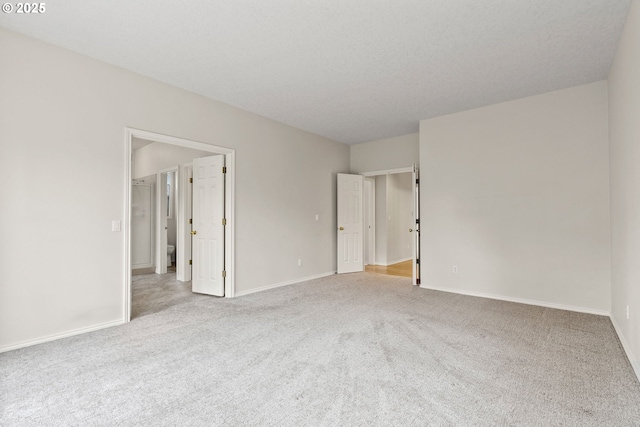 empty room with light colored carpet and a textured ceiling