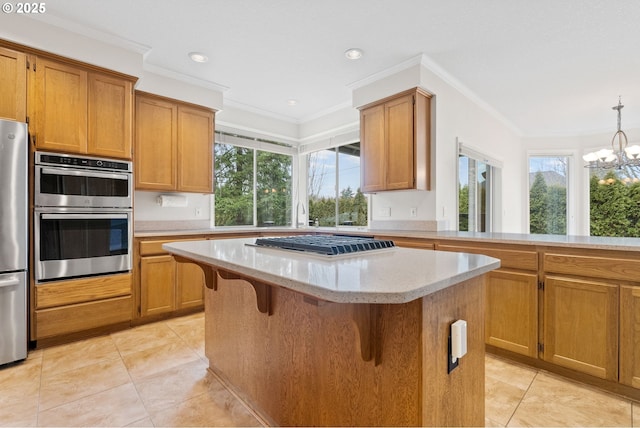 kitchen featuring appliances with stainless steel finishes, pendant lighting, a kitchen breakfast bar, a center island, and crown molding