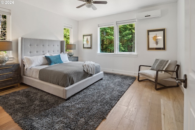 bedroom featuring wood-type flooring, a wall mounted AC, and ceiling fan