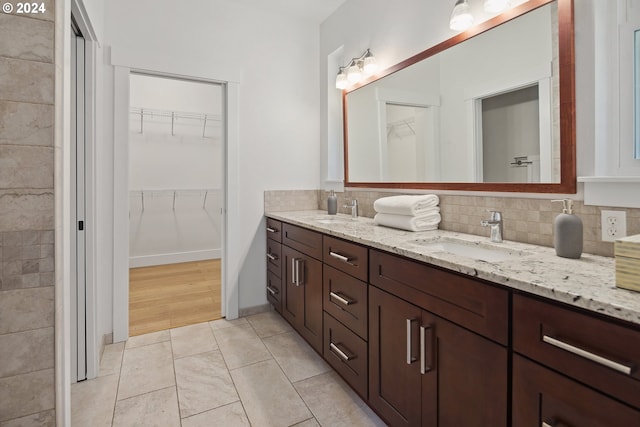 bathroom featuring vanity, backsplash, and tile patterned flooring