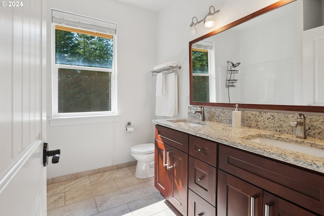 bathroom with vanity, toilet, and a healthy amount of sunlight