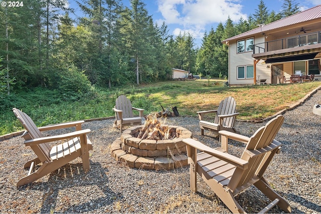 view of patio featuring a balcony and an outdoor fire pit