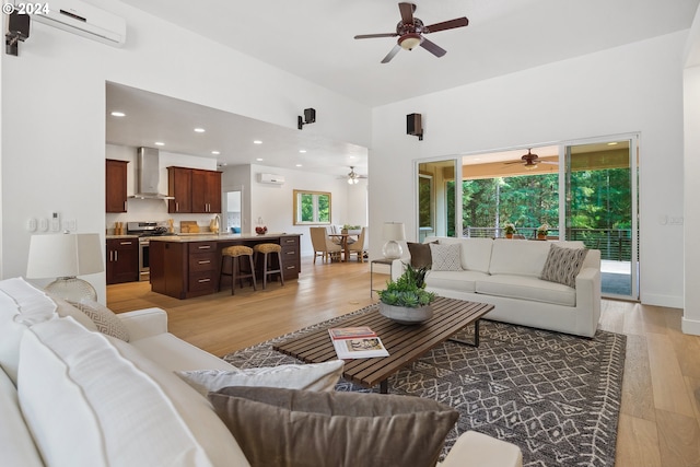 living room with light hardwood / wood-style floors, sink, and a wall unit AC