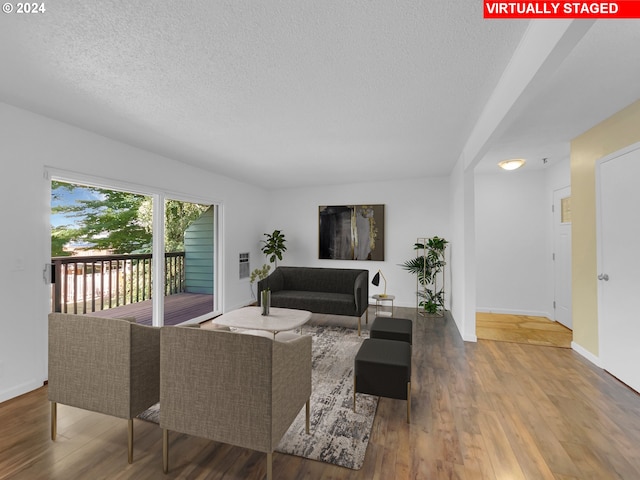 living room with hardwood / wood-style flooring and a textured ceiling