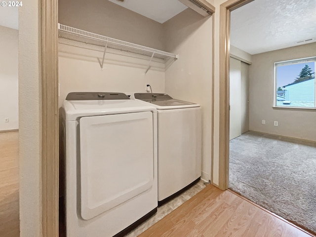 laundry room with light hardwood / wood-style floors and independent washer and dryer