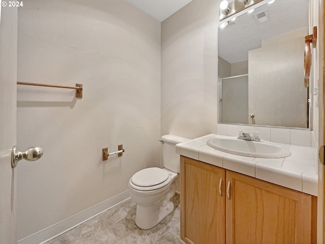 bathroom featuring vanity, toilet, tile patterned floors, and walk in shower