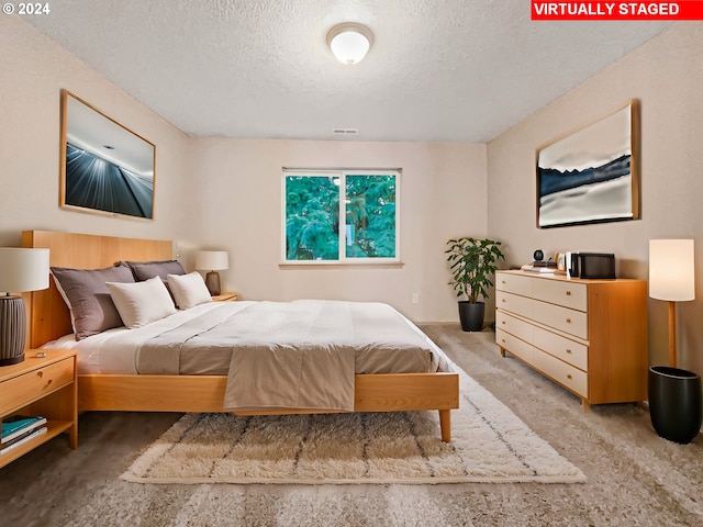 carpeted bedroom with a textured ceiling