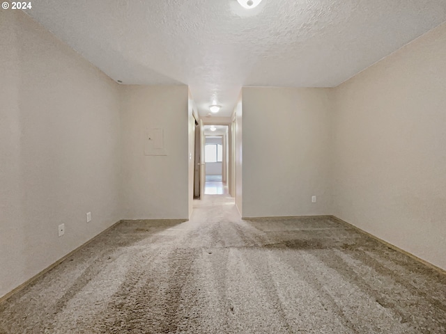 empty room with a textured ceiling and carpet flooring