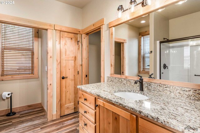 bathroom with a shower with shower door, vanity, and hardwood / wood-style flooring