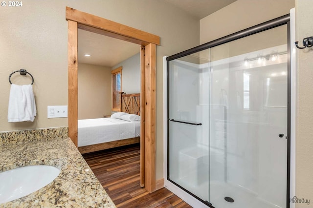 bathroom featuring hardwood / wood-style floors, an enclosed shower, and vanity