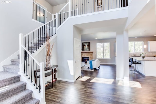 foyer entrance with dark wood-type flooring and a high ceiling