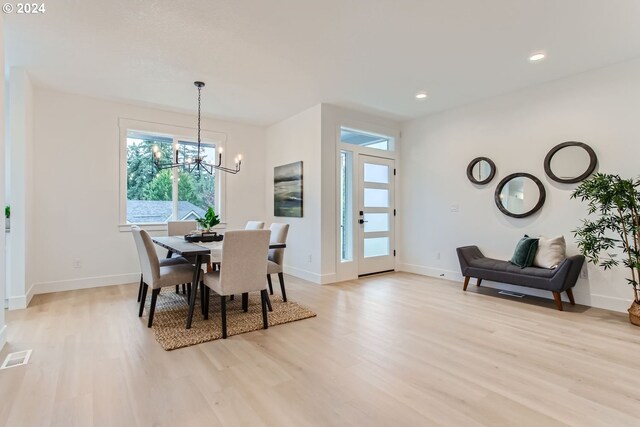 dining space with a chandelier and light hardwood / wood-style flooring