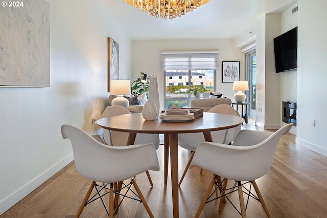 dining room featuring light hardwood / wood-style floors and a chandelier