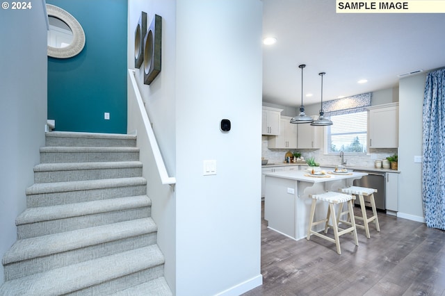 stairway with hardwood / wood-style flooring and sink