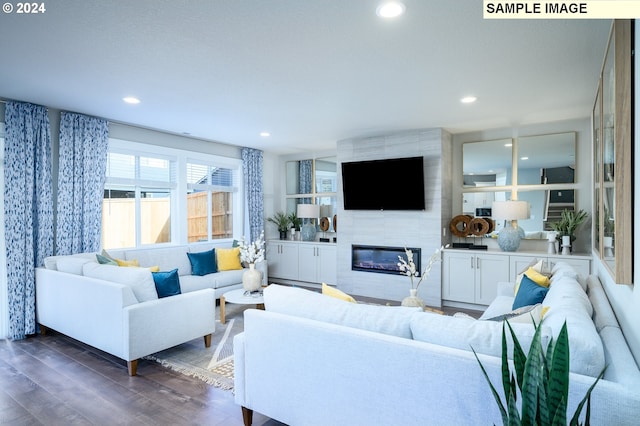 living room featuring dark wood-type flooring and a tile fireplace