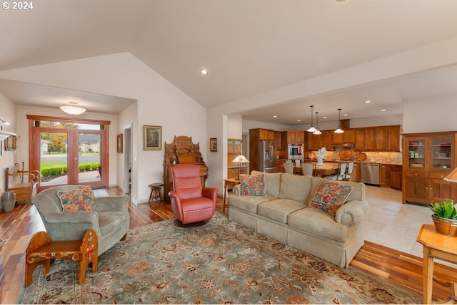 living room featuring french doors, high vaulted ceiling, and light hardwood / wood-style flooring