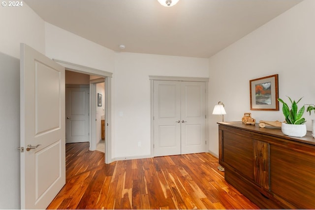 unfurnished bedroom with dark hardwood / wood-style flooring and a closet