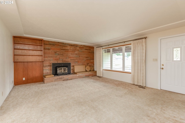 unfurnished living room with light carpet and a wood stove