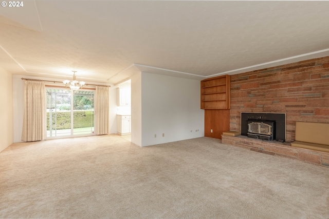 unfurnished living room with carpet floors, an inviting chandelier, and a wood stove