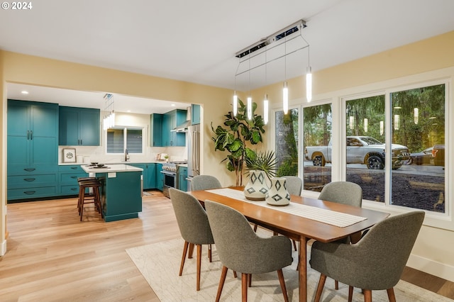 dining space with light hardwood / wood-style flooring and sink