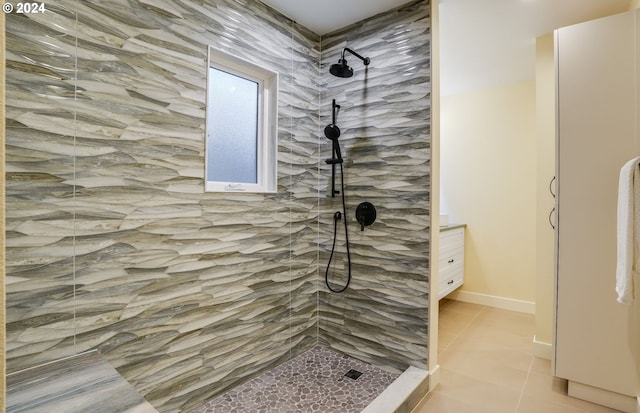 bathroom featuring tile patterned flooring, vanity, and tiled shower