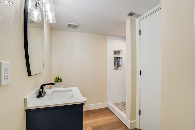 bathroom featuring wood-type flooring, vanity, and walk in shower