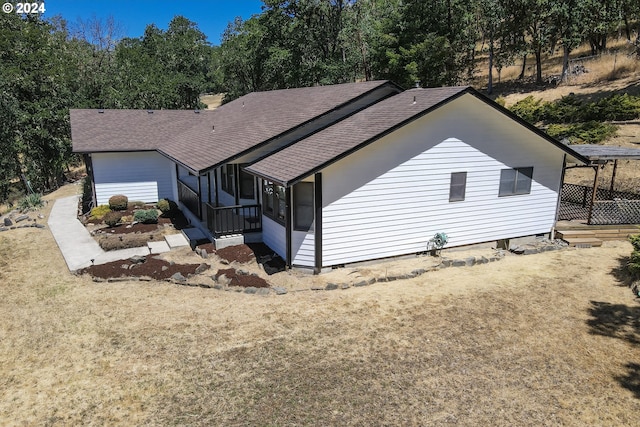 rear view of house featuring a lawn and a sunroom