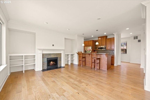 living room featuring a fireplace, light hardwood / wood-style floors, and ornamental molding