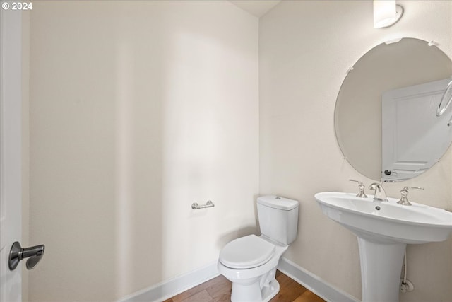 bathroom featuring hardwood / wood-style flooring and toilet