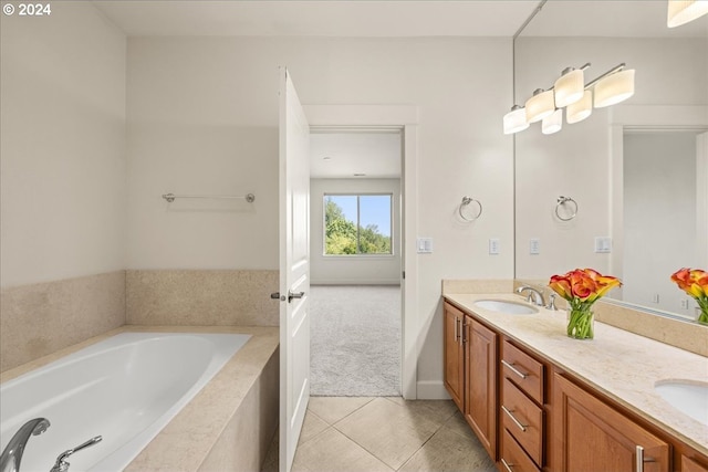 bathroom with tile patterned flooring, vanity, and tiled bath