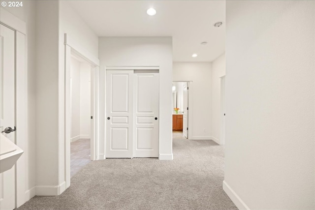 hall with light colored carpet