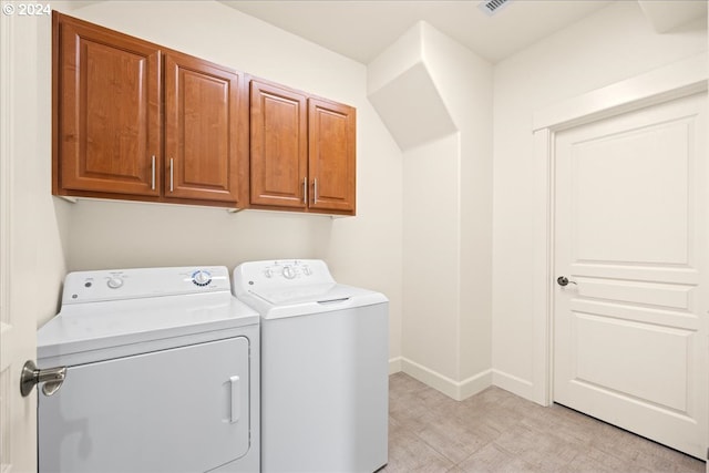 laundry room featuring cabinets and washing machine and clothes dryer