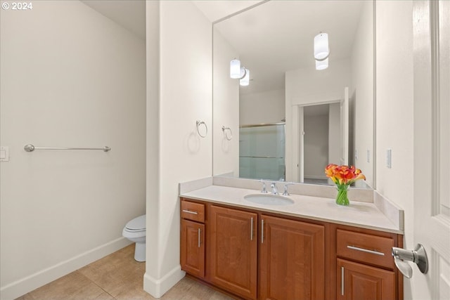 bathroom featuring vanity, toilet, and a shower with shower door