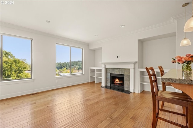 living room with a fireplace, light hardwood / wood-style floors, and ornamental molding