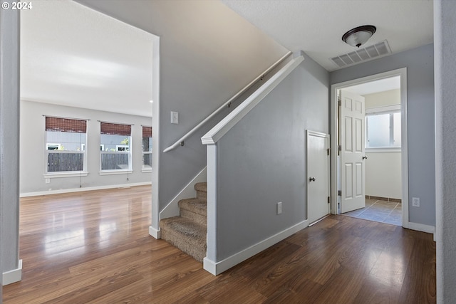 staircase with hardwood / wood-style floors