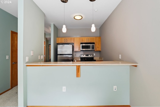 kitchen featuring light colored carpet, kitchen peninsula, a kitchen breakfast bar, appliances with stainless steel finishes, and decorative light fixtures